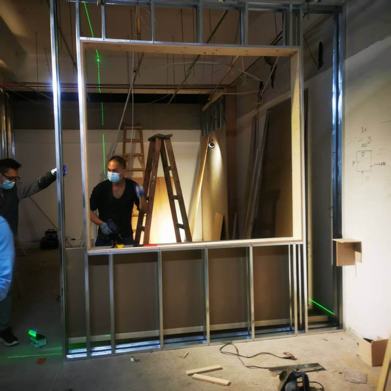 Professional installation technicians using laser levels to align custom hotel wall panels
