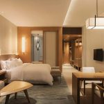 Warm custom wood hotel furniture in a luxury boutique guestroom