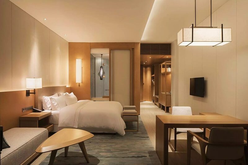 Warm custom wood hotel furniture in a luxury boutique guestroom