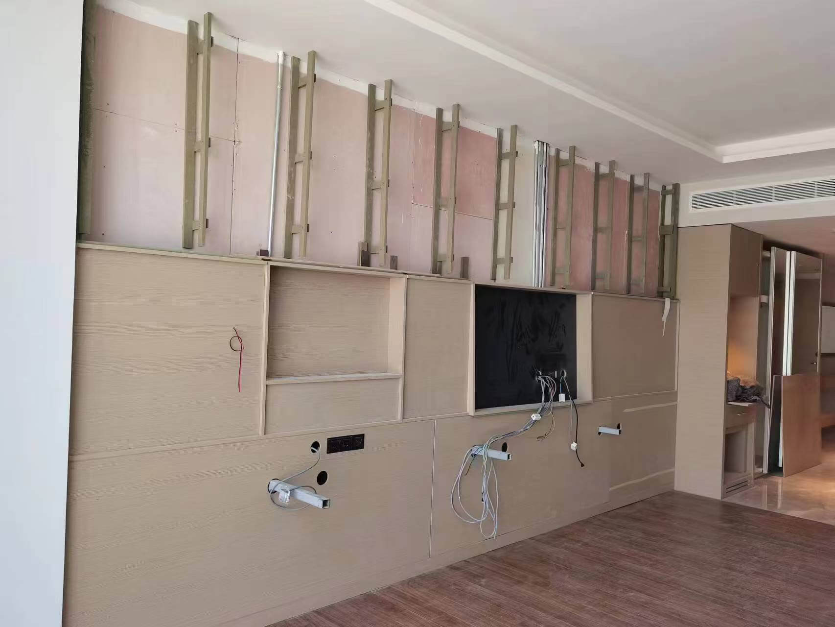 Professional installation technicians using laser levels to align custom hotel wall panels