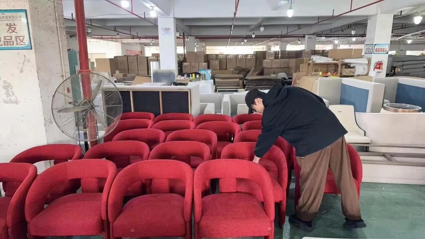 High-quality photo of procurement managers and designers reviewing a custom hotel sofa in a factory